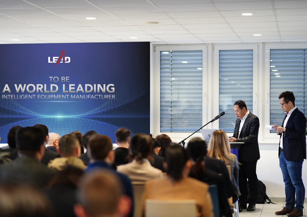 Wang Yanqing speaks to a room full of people in Naila, Germany